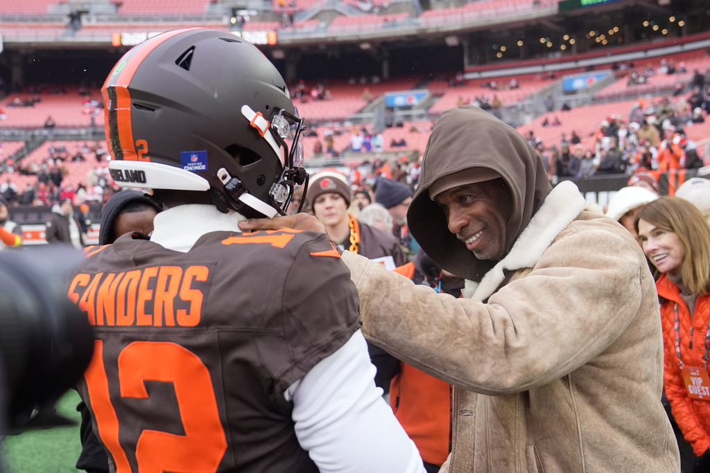 Cleveland Browns quarterback Shedeur Sanders (12) visits with his father Deion Sanders, right, during warmups before an NFL football game against the Tennessee Titans in Cleveland, Sunday, Dec. 7, 2025. (AP Photo/Sue Ogrocki)