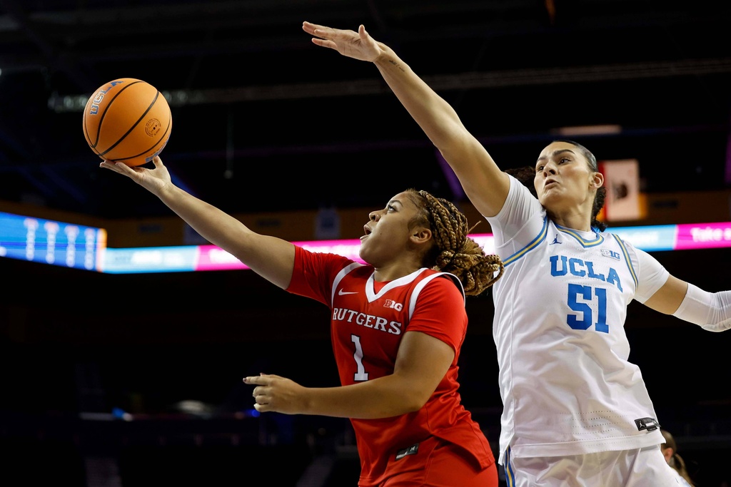 Rutgers guard Lauryn Swann (1) drives to the basket with the ball while being guarded by UCLA center Lauren Betts (51) during the first half of an NCAA college basketball game Wednesday, Feb. 4, 2026, in Los Angeles. (AP Photo/Caroline Brehman)