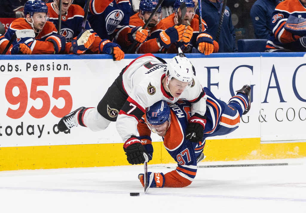 Ottawa Senators' Brady Tkachuk (7) checks Edmonton Oilers' Connor McDavid (97) during overtime NHL action, in Edmonton on Tuesday, March 3, 2026. (Jason Franson/The Canadian Press via AP)