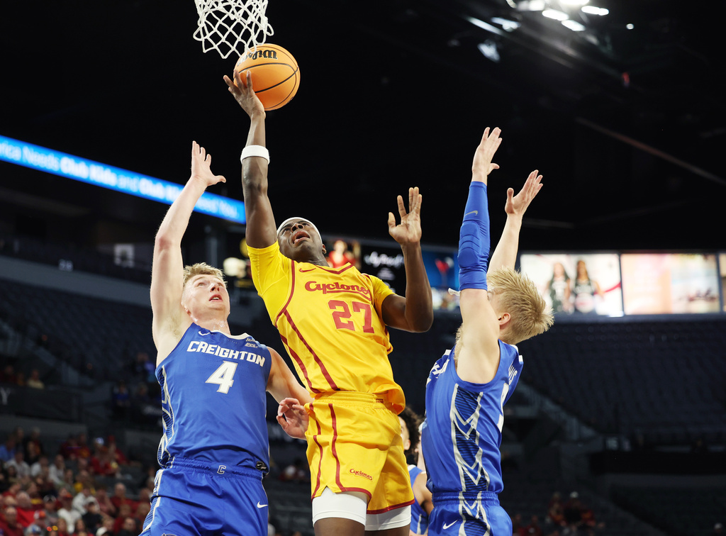 Iowa State guard Killyan Toure (27) is fouled by Creighton guard Josh Dix (4) under the basket during the first half of an NCAA college basketball game Tuesday, Nov. 25, 2025, in Las Vegas. (AP Photo/Ronda Churchill)