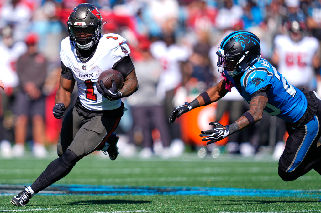 Tampa Bay Buccaneers' Kenny Gainwell (1) runs past Carolina Panthers' Zakee Wheatley (20) during the first half of an NFL football game in Charlotte, N.C., Sunday, Oct. 25, 2026. (AP Photo/Erik Verduzco)