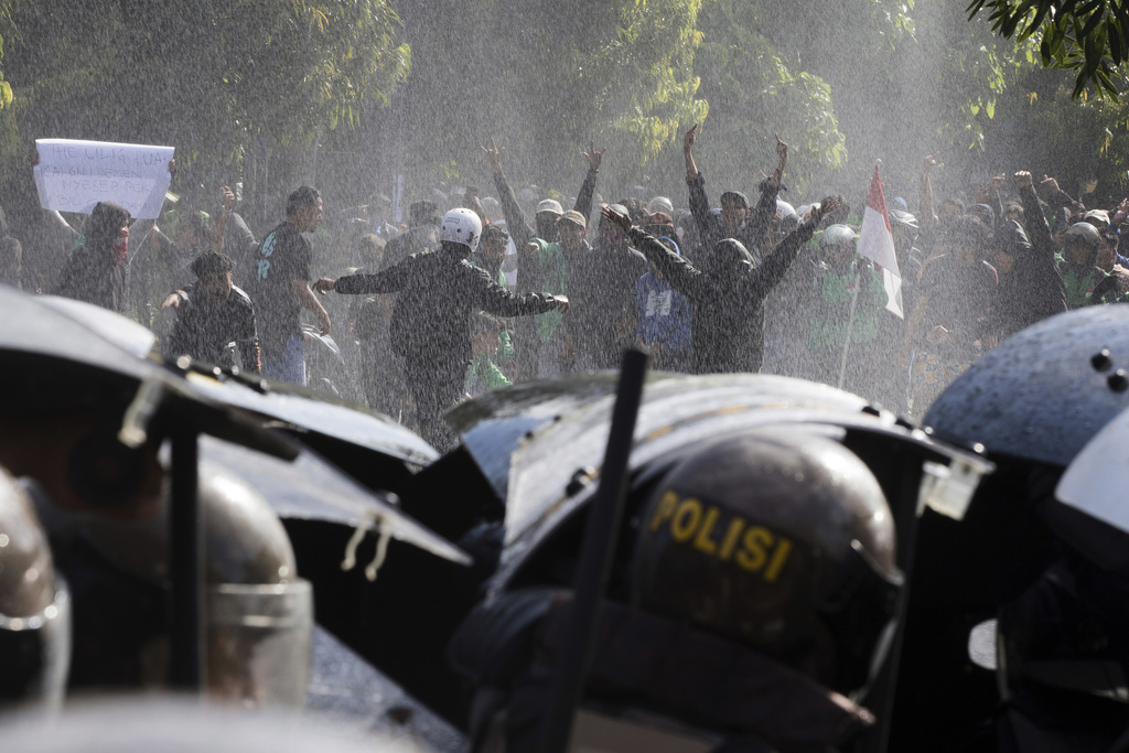 People taunt riot police during a protest against lavish lawmakers' allowance, in Denpasar, Bali, Indonesia, Saturday, Aug. 30, 2025. (AP Photo/Firdia Lisnawati)