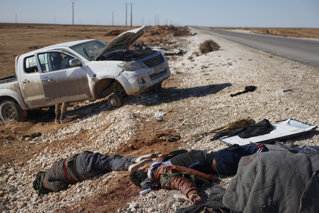 FILE - The bodies of retreating Syrian Democratic Forces fighters lie on the side of the road between government-controlled Raqqa and SDF-controlled Hassakeh, in northeastern Syria, Tuesday, Jan. 20, 2026. (AP Photo/Omar Albam, File)
