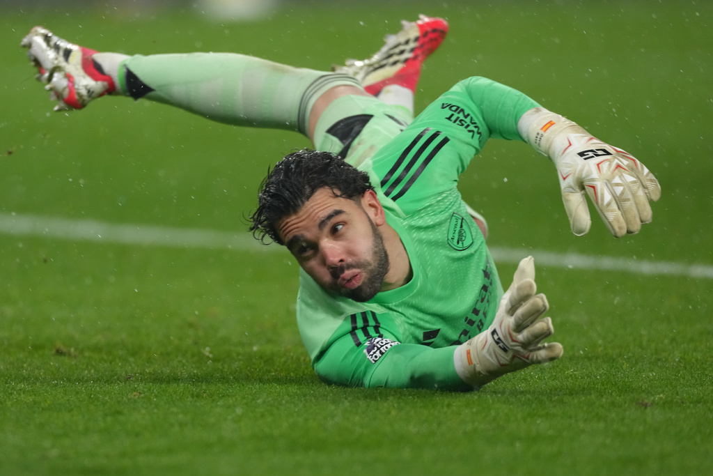 Arsenal's goalkeeper David Raya tries to block a shot during the Premier League soccer match between Wolverhampton Wanderers and Arsenal in Wolverhampton, England, Wednesday, Feb. 18, 2026. (AP Photo/Dave Shopland)