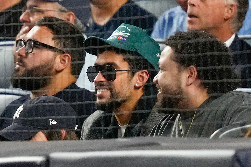 Bad Bunny, center, watches play between the New York Yankees and the Toronto Blue Jays during the second inning of Game 3 of baseball's American League Division Series, Tuesday, Oct. 7, 2025, in New York. (AP Photo/Yuki Iwamura)