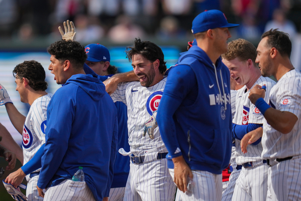 Chicago Cubs' Dansby Swanson, center, celebrates with teammates after driving in the game-winning run in the 10th inning of a baseball game against the Philadelphia Phillies, Thursday, April 23, 2026, in Chicago. (AP Photo/Erin Hooley)