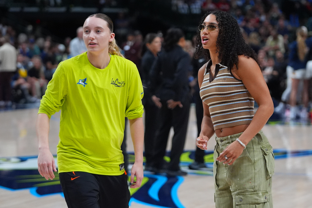 An inured Dallas Wings guard Azzi Fudd, right, talk to teammate and fellow guard Paige Bueckers before the first half of a WNBA basketball game against the Indiana Fever in Dallas, Thursday, Aug. 20, 2026. (AP Photo/LM Otero)