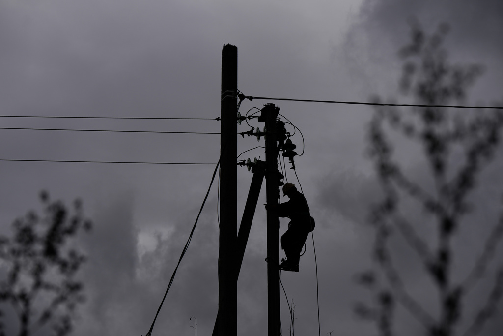 A worker climbs a utility pole while repairing power lines damaged by a Russian attack, Thursday, Oct. 16, 2025, in Shostka, Ukraine. (AP Photo/Julia Demaree Nikhinson)