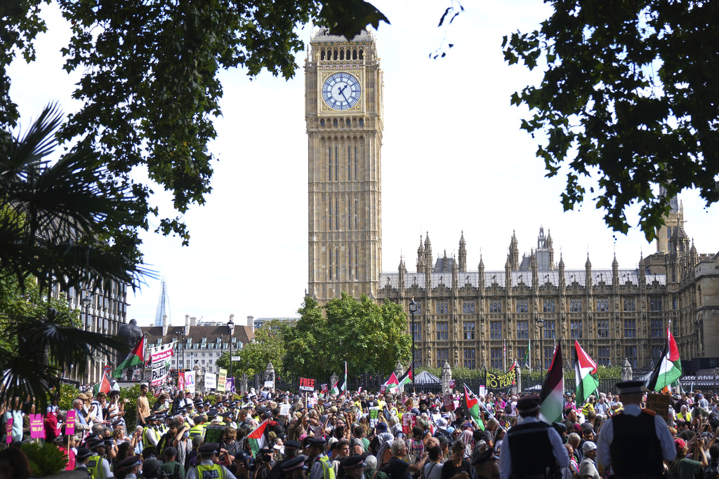 Prortesters in Parliament Square are watched by police during a protest to support Palestine Action in London, Saturday, Sept. 6, 2025.(AP Photo/Joanna Chan)