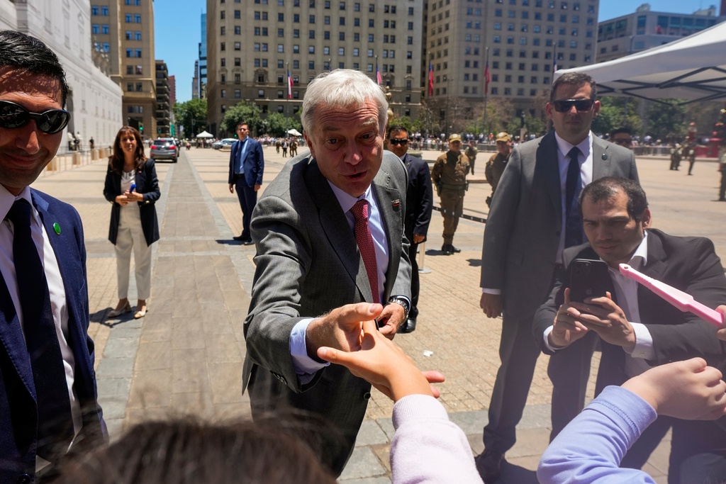 Chilean President-elect Jose Antonio Kast greets supporters at La Moneda palace after meeting with President Gabriel Boric the day after he won the presidential election runoff in Santiago, Chile, Monday, Dec. 15, 2025. (AP Photo/Esteban Felix)