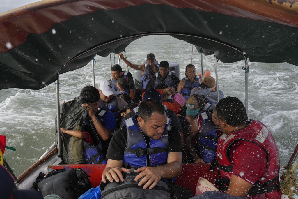 FILE - Luis Sanchez, center, sits with other Venezuelan migrants on a boat leaving Gardi Sugdub on Panama's Caribbean coast, Feb. 23, 2025, after giving up hopes of reaching the U.S. while in southern Mexico amid President Trump's crackdown on migration. (AP Photo/Matias Delacroix, File)