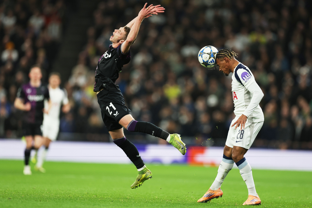 Slavia's David Doudera, left, grimaces as Tottenham's Wilson Odobert heads the ball during the Champions League opening phase soccer match between Tottenham and Slavia Prague, in London, England, Tuesday, Dec. 9, 2025. (AP Photo/Richard Pelham)