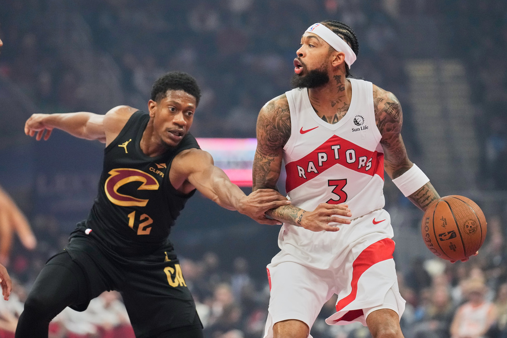 Cleveland Cavaliers' De'Andre Hunter (12) defends Toronto Raptors' Brandon Ingram (3) in the first half of an an NBA Cup basketball game in Cleveland, Friday, Oct. 31, 2025. (AP Photo/Sue Ogrocki)