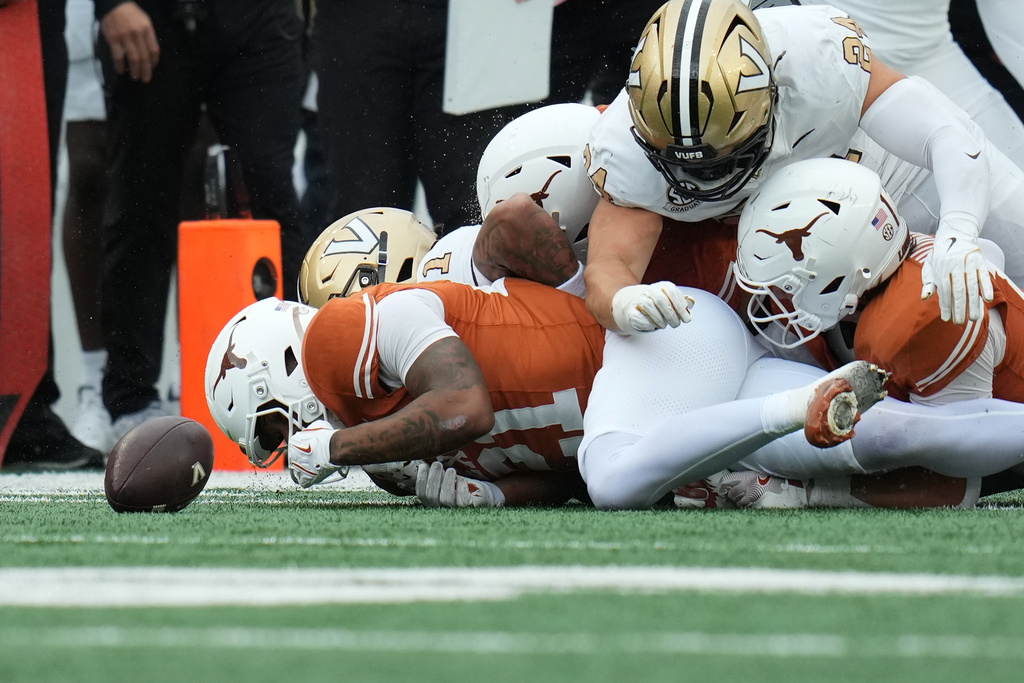 Texas wide receiver Ryan Niblett (21) dives ahead of Vanderbilt players for an onside kick during the second half of an NCAA college football game in Austin, Texas, Saturday, Nov. 1, 2025. (AP Photo/Eric Gay)