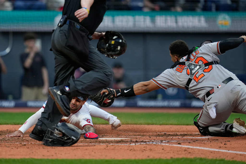 Cleveland Guardians' Brayan Rocchio, left, scores under the tag of Baltimore Orioles catcher Samuel Basallo (29) on a single hit by Steven Kwan in the fifth inning of a baseball game in Cleveland, Thursday, April 16, 2026. (AP Photo/Sue Ogrocki)