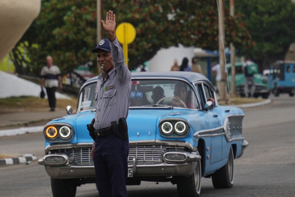 A National Police officer directs traffic due to a power outage in Havana, Cuba, Wednesday, Dec. 3, 2025. (AP Photo/Ramon Espinosa)