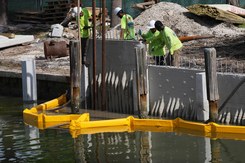 Workers install a 3D-printed living seawall manufactured by Kind Designs at the Church by the Sea, Tuesday, Aug. 4, 2026, in Fort Lauderdale, Fla. (AP Photo/Lynne Sladky)
