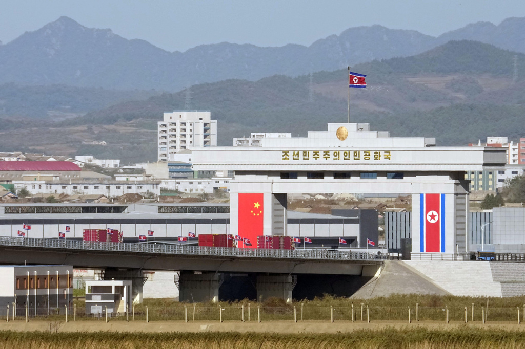 National flags of China and North Korea are seen around a gate leading to a North Korean customs facility, seen from Dandong, China, ahead of the opening ceremony of the China-North Korea Yalu River Bridge at the border between the two countries Wednesday, Oct. 14, 2026. (Iori Sagisawa/Kyodo News via AP)