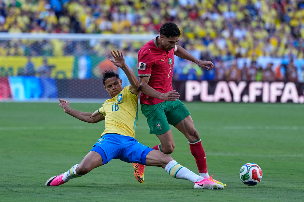 Brazil's Douglas Santos, left, challenges Morocco's Achraf Hakimi during the World Cup Group C soccer match between Brazil and Morocco in East Rutherford, N.J., near New York, Saturday, June 13, 2026. (AP Photo/Petr David Josek)