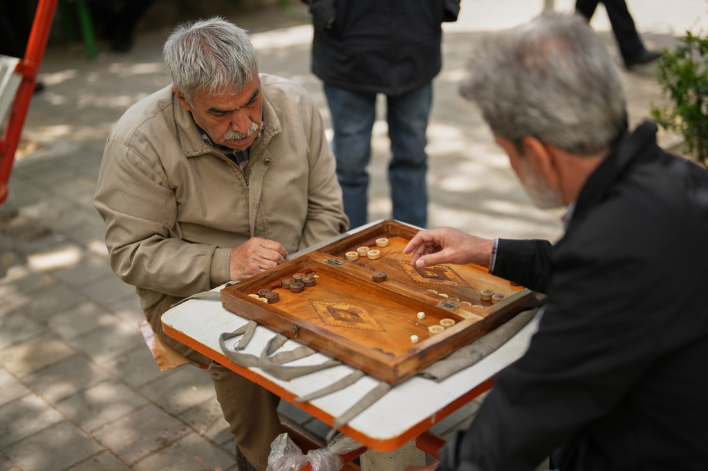 Ali Asghar Nasrulahi, 66, a veteran of the Iran-Iraq war, plays backgammon with a friend in a public park in Tehran, Wednesday, April 8, 2026. (AP Photo/Francisco Seco)