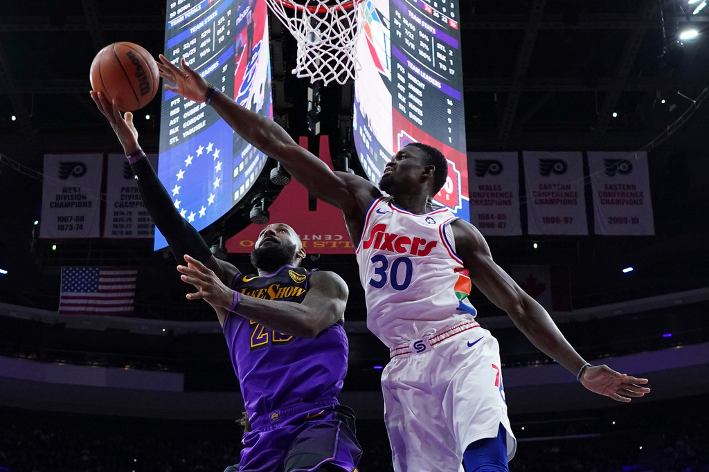 FILE - Los Angeles Lakers' LeBron James, left, goes up for a shot past Philadelphia 76ers' Adem Bona during the second half of an NBA basketball game, Jan. 28, 2025, in Philadelphia. (AP Photo/Matt Slocum, File)