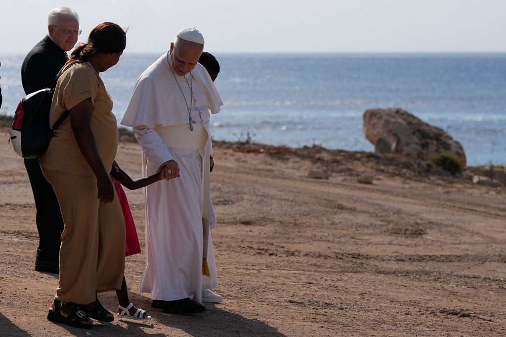 Pope Leo XIV walks together with a migrant family at the Gateway of Europe monument in Lampedusa, Sicily, southern Italy, Saturday, July 4, 2026, during a one-day pastoral visit to the island long associated with the plight of migrants crossing the Mediterranean. (AP Photo/Alessandra Tarantino)