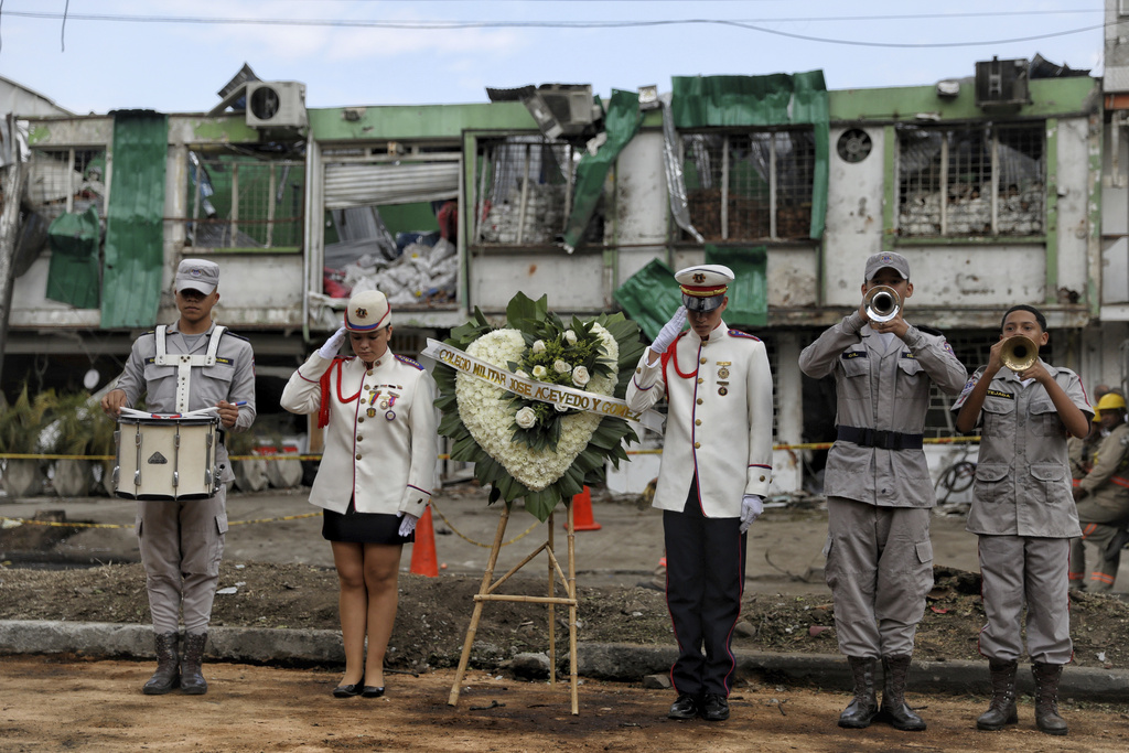 A military school band performs to honor people killed a day earlier by a car bomb explosion outside an Air Force base in Cali, Colombia, Aug. 22, 2025. (AP Photo/Santiago Saldarriaga)