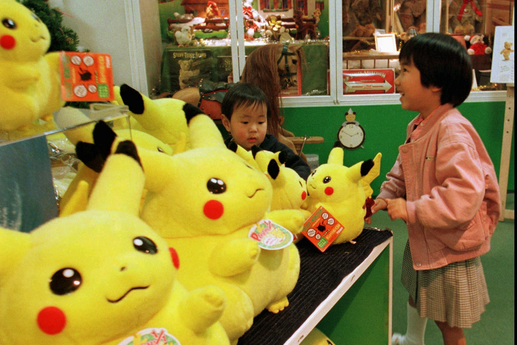 A Japanese girl and her brother play with dolls of a popular cartoon character, "Pokemon," at a toy shop in Tokyo's Ginza shopping district, Dec. 18, 1997. (AP Photo/Naokazu Oinuma, File)