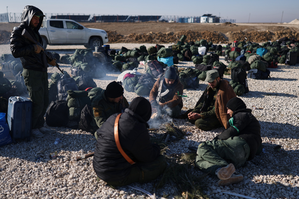 Syrian government forces with their luggage wait to enter the al-Hol camp in northeastern Syria's Hasakeh province, Syria, Wednesday, Jan. 21, 2026, after the withdrawal of the Syrian Democratic Forces (SDF). (AP Photo/Ghaith Alsayed)