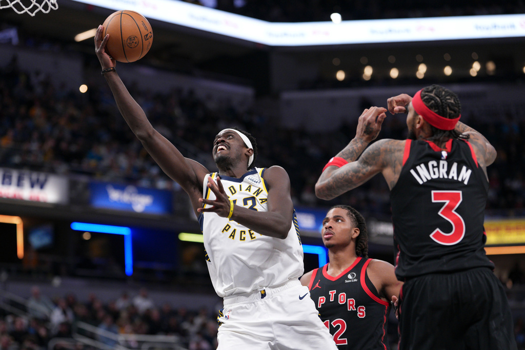 Indiana Pacers forward Pascal Siakam (43) shoots between Toronto Raptors defenders Collin Murray-Boyles (12) and Brandon Ingram (3) during the first half of an NBA basketball game in Indianapolis, Wednesday, Jan. 14, 2026. (AP Photo/AJ Mast)