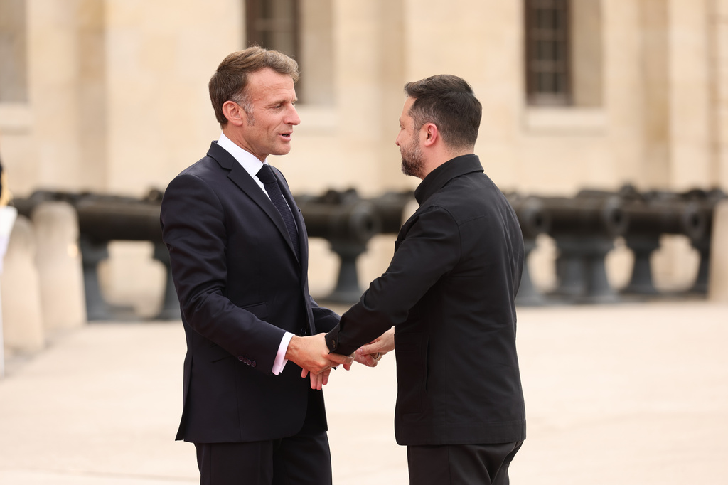 French President Emmanuel Macron greets Ukrainian President Volodymyr Zelensky ahead of the Coalition of the Willing summit on security guarantees for Ukraine at the Hotel des Invalides in Paris, France, Monday, July 13, 2026. (Teresa Suarez/POOL photo via AP)