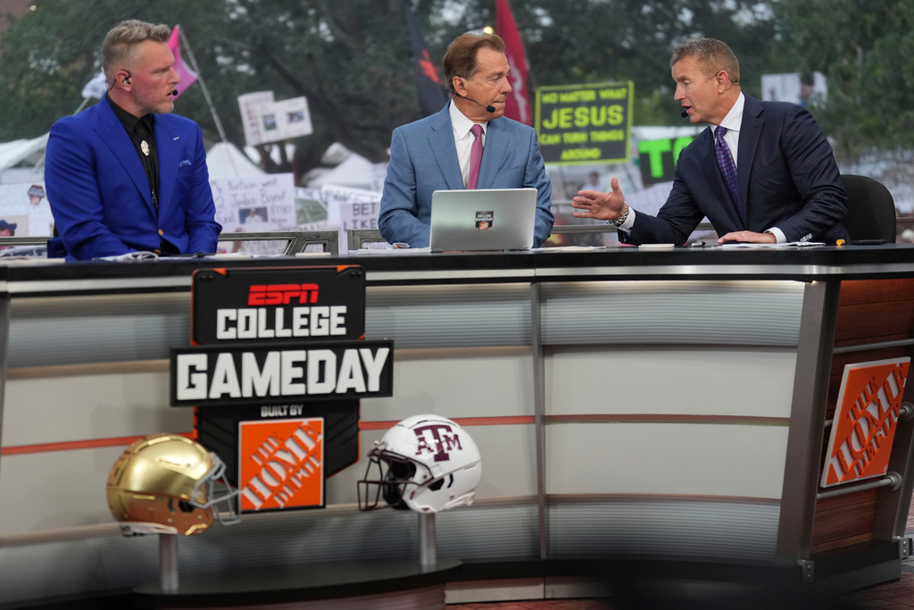 FILE - From left, Pat Mcafee, Nick Saban and Kirk Herbstreit talk on the set of ESPN College Gameday on Saturday, Aug. 31, 2024, in College Station, Texas. (AP Photo/Sam Craft, File)