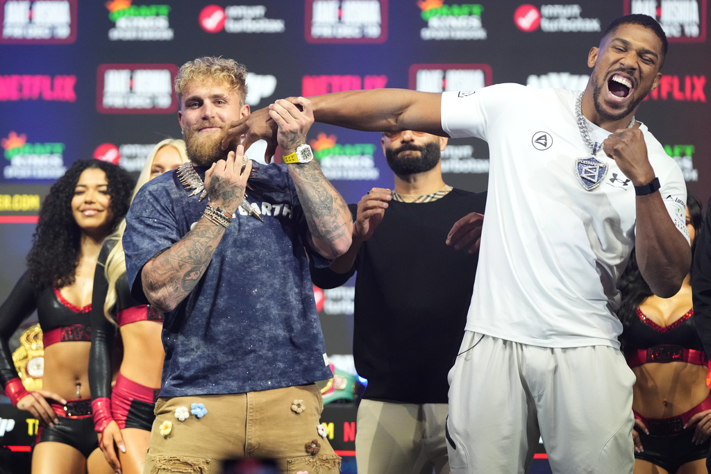 Jake Paul, left, and Anthony Joshua face off during a news conference promoting their upcoming heavyweight boxing match, Wednesday, Dec. 17, 2025, in Miami Beach, Fla. (AP Photo/Lynne Sladky)