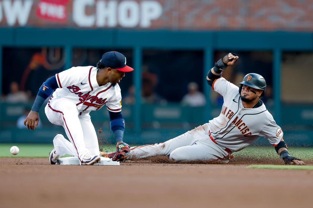 San Francisco Giants' Luis Arraez, right, steals second base against Atlanta Braves second baseman Ozzie Albies, left, during the first inning of a baseball game, Wednesday, June 17, 2026, in Atlanta. (AP Photo/Erik S. Lesser)