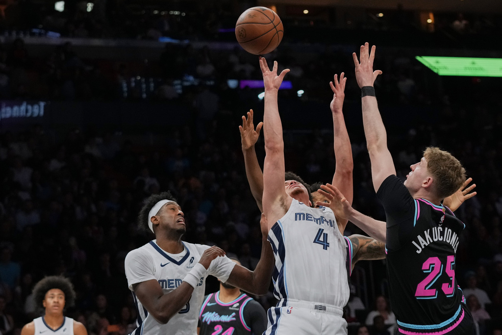 Memphis Grizzlies guard Walter Clayton Jr. (4) attempts a shot as Miami Heat guard Kasparas Jakucionis (25) defends during the first half of an NBA basketball game, Saturday, Feb. 21, 2026, in Miami. (AP Photo/Lynne Sladky)