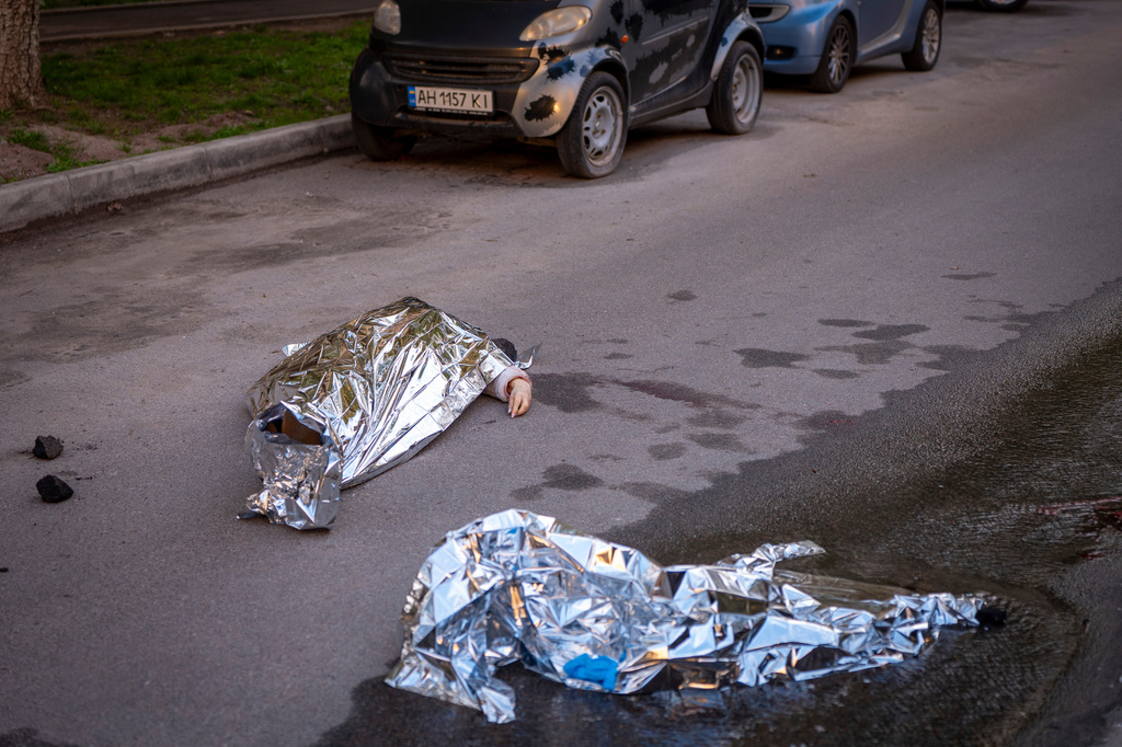 Bodies of victims are seen at the site where a gunman killed at least six people in the streets before being shot dead by police, in Kyiv, Ukraine, Saturday, April 18, 2026. (AP Photo/Dan Bashakov)