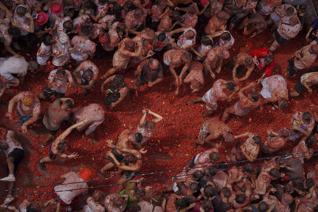 Revelers throw tomatoes at each other during the annual "Tomatina" tomato fight fiesta, in the village of Bunol near Valencia, Spain, Wednesday, Aug. 27, 2025. (AP Photo/Alberto Saiz)