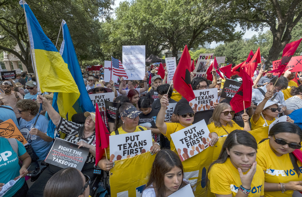 Supporters gather in the shade during the Fight The Trump Takeover Rally held at the State Capitol, Saturday, Aug. 16, 2025, in Austin, Texas, to protest congressional redistricting efforts by Texas Republicans and President Donald Trump. (AP Photo/Rodolfo Gonzalez)