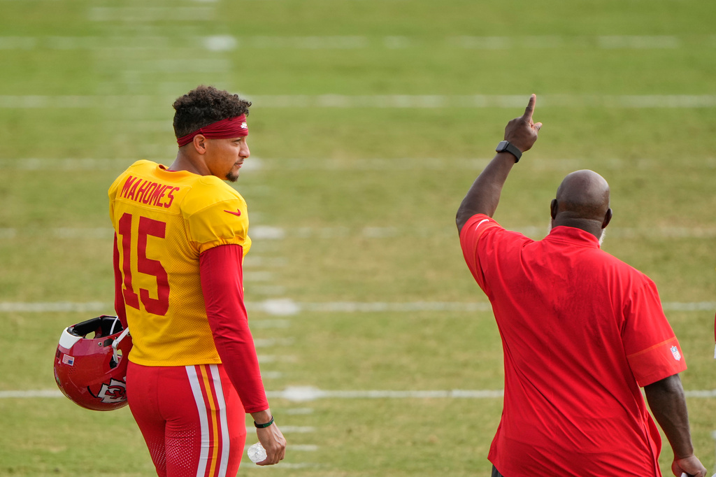 Kansas City Chiefs quarterback Patrick Mahomes (15) talks with offensive coordinator Eric Bieniemy during NFL football training camp Tuesday, Aug. 11, 2026, in St. Joseph, Mo. (AP Photo/Charlie Riedel)