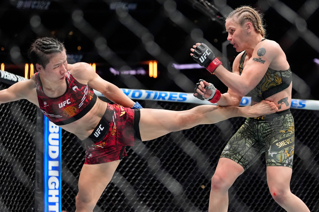 China's Zhang Weili, left, kicks Kyrgyzstan's Valentina Shevchenko, right, during the fourth round of a women's flyweight title bout at the UFC 322 mixed martial arts event, Saturday, Nov. 15, 2025, in New York. (AP Photo/Yuki Iwamura)
