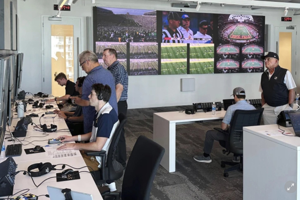 FILE - Alberto Riveron, second left, the Atlantic Coast Conference supervisor of football officials, works in the league's new gameday operations center, Saturday, Sept. 2, 2023, in Charlotte, N.C. (AP Photo/Aaron Beard, File)