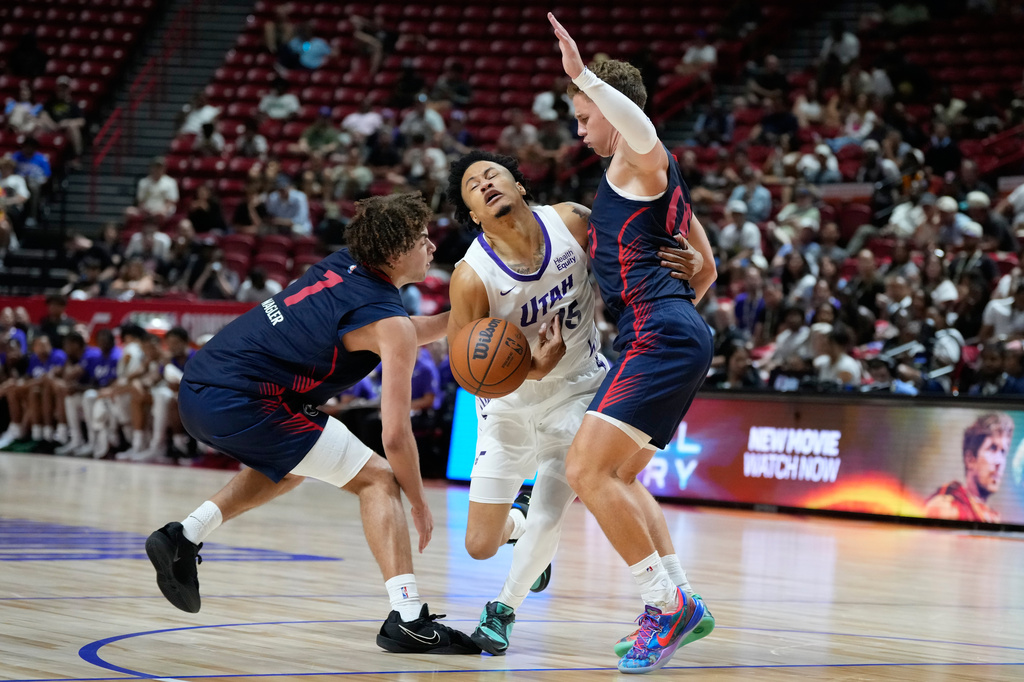 Utah Jazz's Trey Alexander, center, drives against LA Clippers' Keaton Wagler, left, and LA Clippers' Sean Pedulla during the second half of an NBA Summer League basketball game Sunday, July 12, 2026, in Las Vegas. (AP Photo/John Locher)