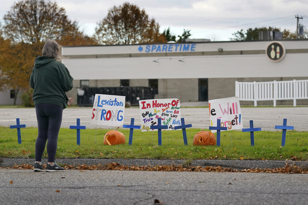 FILE - A woman visits a makeshift memorial outside Sparetime Bowling Alley, the site of a mass shooting, in this Oct. 28, 2023 file photo, in Lewiston, Maine. (AP Photo/Robert F. Bukaty, File)