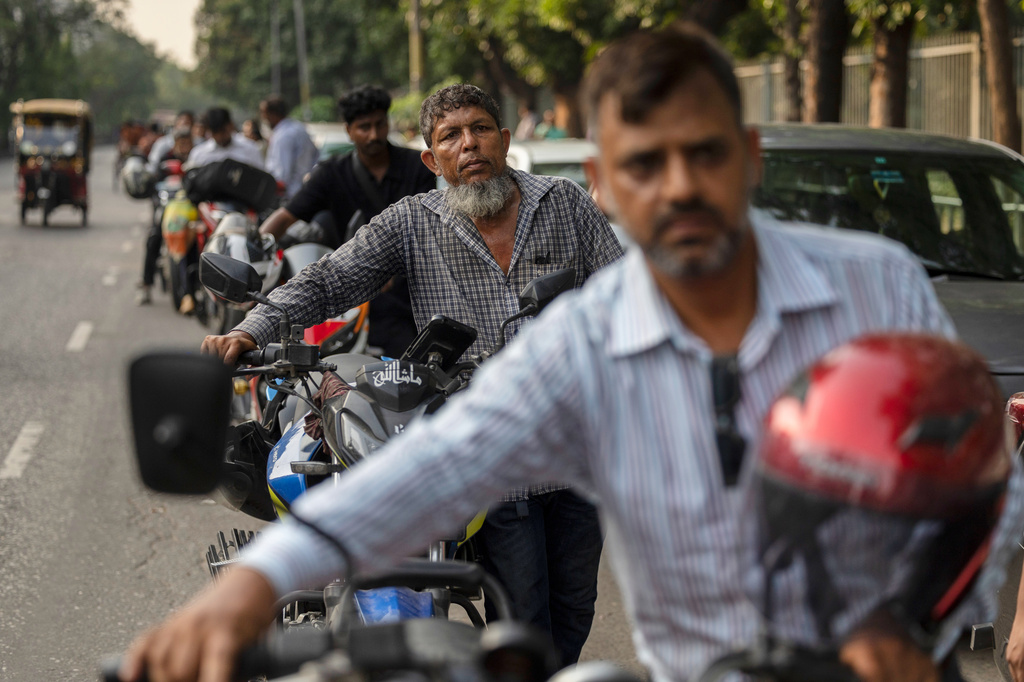 Tariqul Islam, a ride-share driver, waits in a long queue of petrol for his motorcycle in Dhaka, Bangladesh, Tuesday, April 23, 2026. (AP Photo/Abdul Goni)