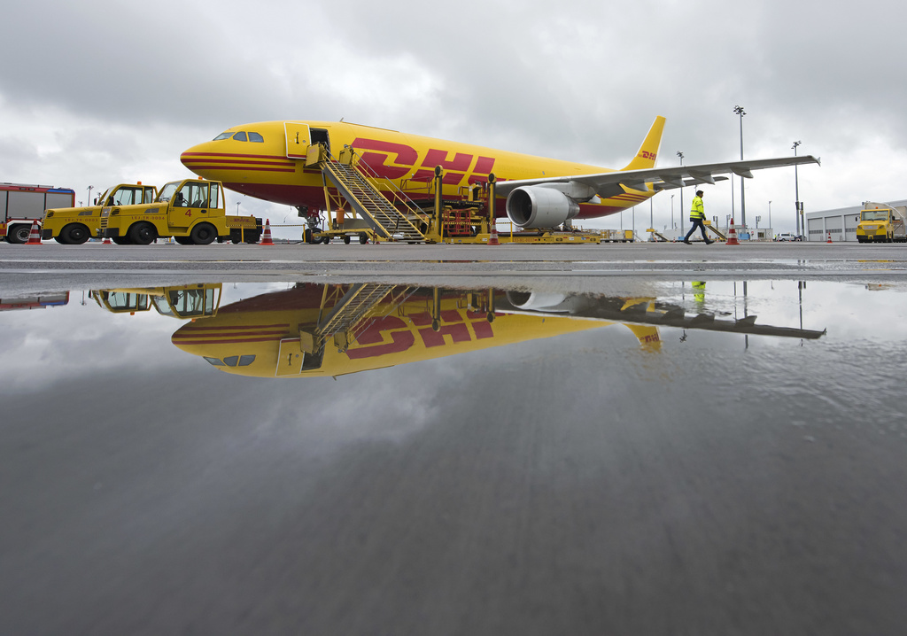 FILE -An DHL airplane reflects in the water during the opening of the new sorting center at its European DHL Express air freight hub in Schkeuditz near Leipzig, Germany, Oct. 12, 2016. (AP Photo/Jens Meyer, File)