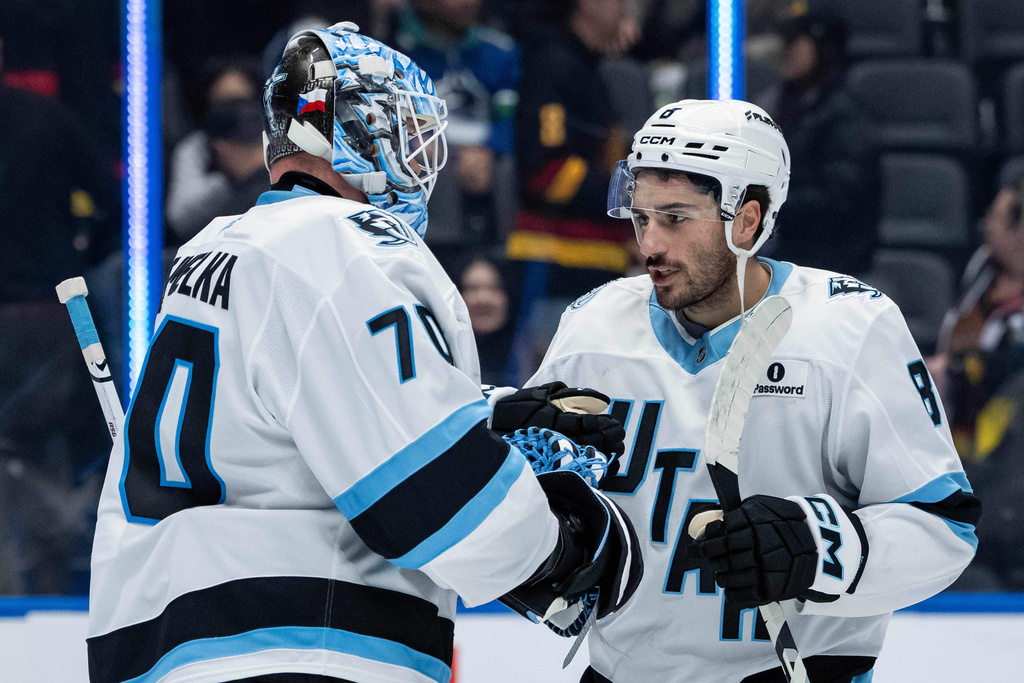 Utah Mammoth goaltender Karel Vejmelka (70) and Nick Schmaltz (8) celebrate after their team defeated the Vancouver Canucks in an NHL hockey game in Vancouver, British Columbia, Friday, Dec. 5, 2025. (Ethan Cairns/The Canadian Press via AP)