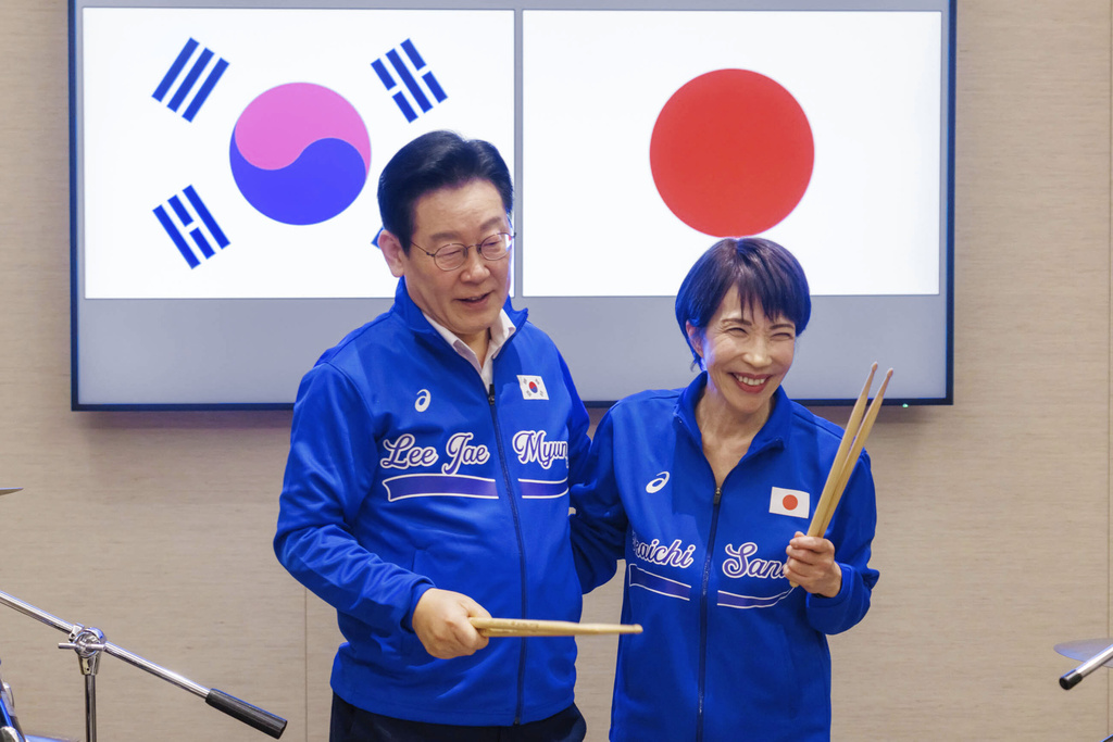 In this photo released on the official website of Prime Minister's Office of Japan, Japanese Prime Minister Sanae Takaichi, right, and South Korean President Lee Jae Myung react as they play drump together after their talks in Nara, western Japan Tuesday, Jan. 13, 2026. (Prime Minister's Office of Japan via AP)