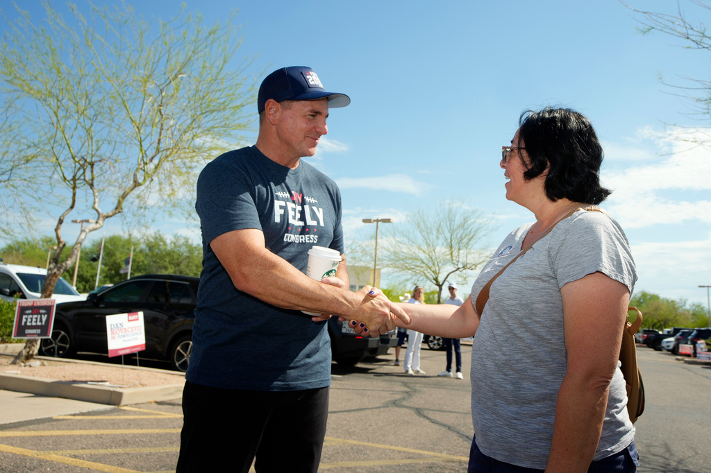 Jay Feely, left, a Republican candidate for Arizona's 1st Congressional District, shakes hands with a voter at a polling place on Arizona primary election day, Tuesday, July 21, 2026, in Fountain Hills, Ariz. (AP Photo/Ross D. Franklin)