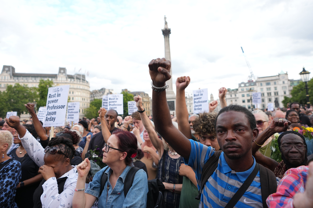 People gesture as they attend a vigil held by Stand Up to Racism, in memory of late University of Cambridge professor Jason Arday, in Trafalgar Square in London, Monday, Aug. 17, 2026. (AP Photo/Kirsty Wigglesworth)