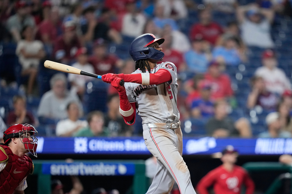 Washington Nationals' CJ Abrams follows through hitting a two-run triple against Philadelphia Phillies' Caleb Kilian during the 11th inning of a baseball game Wednesday, Aug. 5, 2026, in Philadelphia. (AP Photo/Matt Slocum)